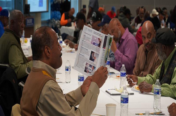 Man reading a pamphlet while at the dinner table 