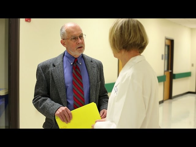 A female doctor and man standing in a hallway talking