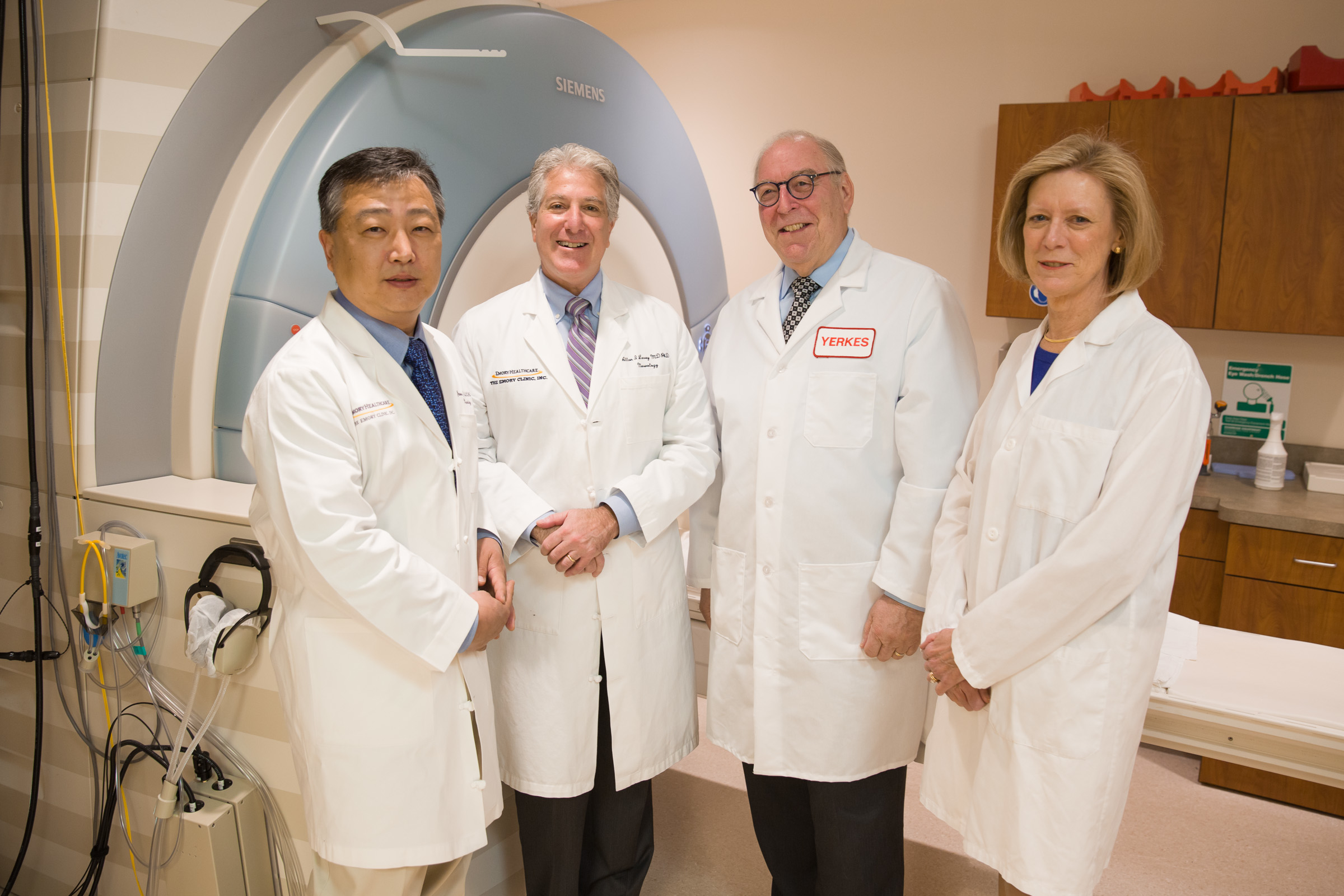 four doctors standing in front of the scanner